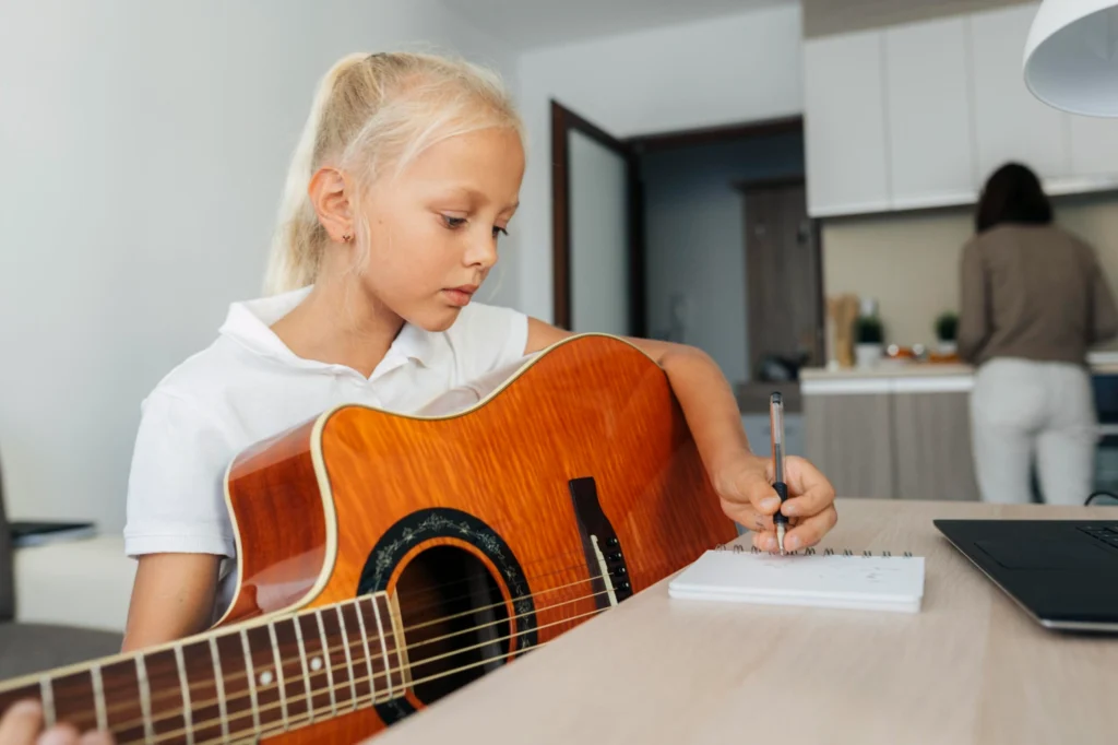 Момиче се учи да свири на  китара